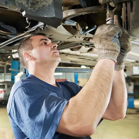 Technician at work under a vehicle